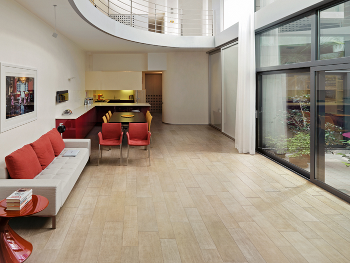 Expressieve woonkamer met lichte houtlook tegelvloer en rode accenten